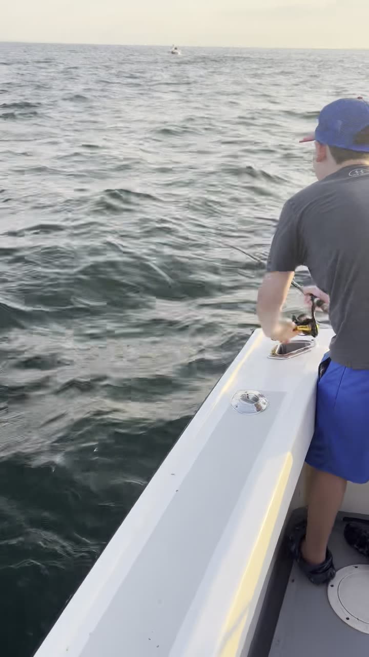 Quiet dusk fishing on the central Long Island Sound aboard the Christina M II — rod bent, landing net ready. A private charter with Captain Skippy out of Mount Sinai, NY.